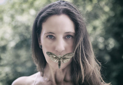 Close-up portrait of woman with insect on mouth