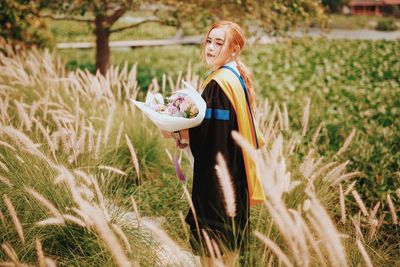 Portrait of young woman sitting on field