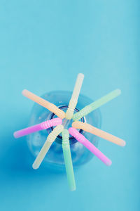 Colorful plastic straws over blue background