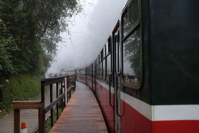 Footbridge over lake against sky