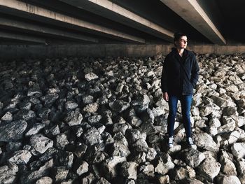 Portrait of young woman standing on stack of firewood