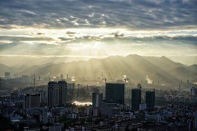 Buildings in city against sky during sunset