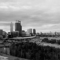 Skyscrapers in city against cloudy sky