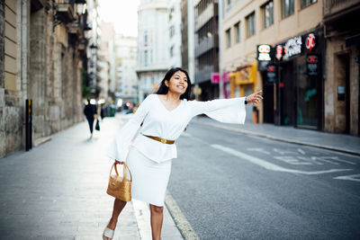 Woman standing on road in city