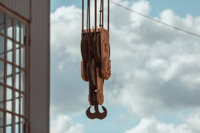 Low angle view of electric hanging against sky