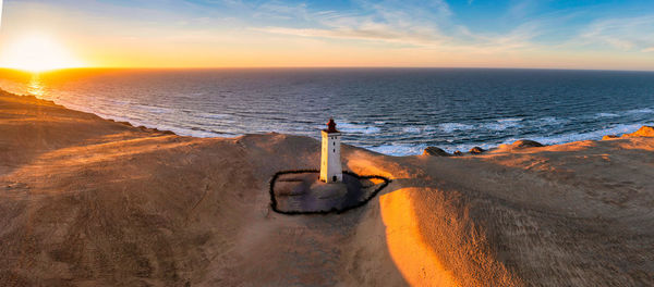 Rubjerg knude fyr lighthouse in sunset from drone