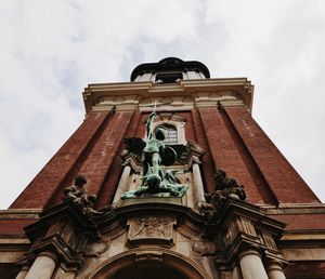 Low angle view of statue against building against sky