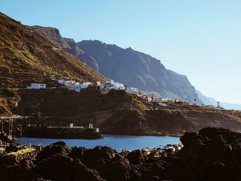 Scenic view of sea and rocks against clear sky