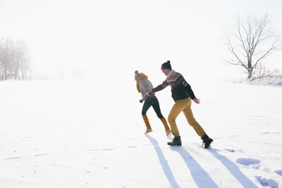 Full length of people on snow covered land