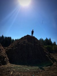 Low angle view of man standing on mountain against sky