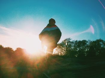 Rear view of silhouette man against sky on sunny day