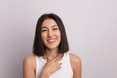 Portrait of young woman against white background