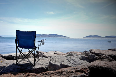 Deck chairs on beach against sky