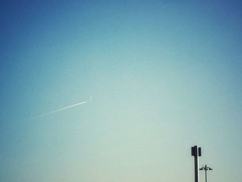 Low angle view of vapor trail against clear blue sky