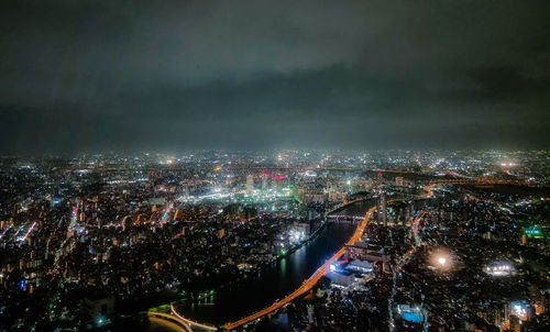 High angle view of illuminated city against sky at night