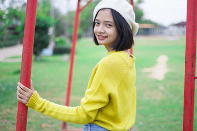 Portrait of smiling girl holding yellow outdoors