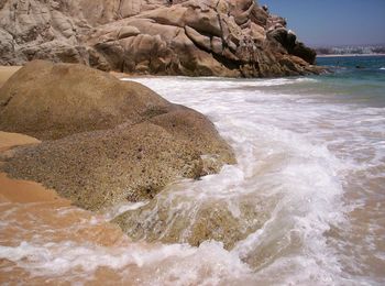 Close-up of wave on beach against sky