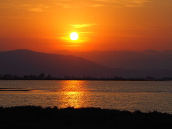 Scenic view of lake against sky during sunset