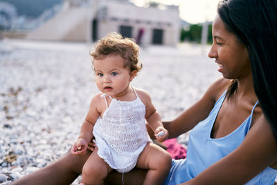 Mother and baby girl sitting outdoors