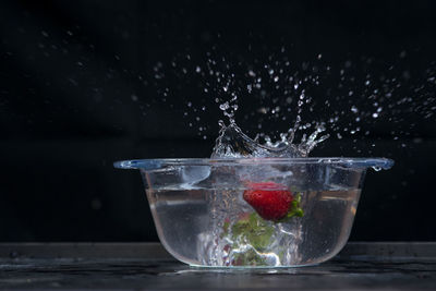 Close-up of glass of water splashing on table