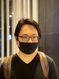 Portrait of young man wearing eyeglasses and face mask.