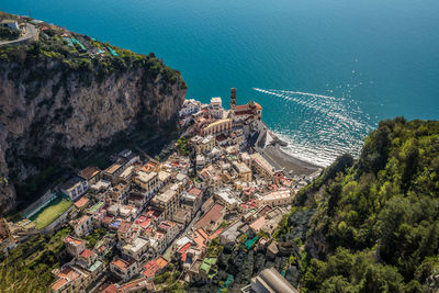 High angle view of houses on mountain by sea during sunny day