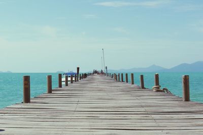 Wooden pier on sea against sky