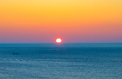 Scenic view of sea against romantic sky at sunset