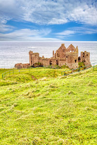 Old ruins by sea against sky