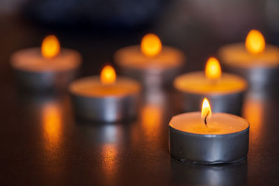 Close-up of lit tea light candles in temple