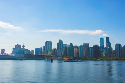 Sea by buildings against sky in city