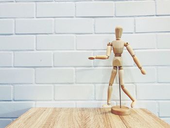 Close-up of figurine on table against wall