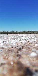 Surface level of land against clear blue sky