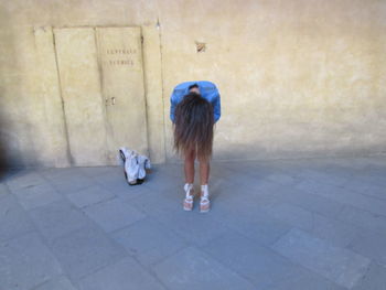 Rear view of woman walking on footpath