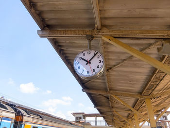 Low angle view of clock hanging on ceiling of building