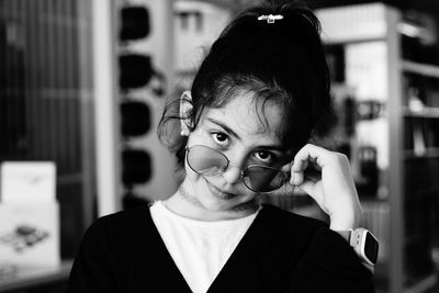 Portrait of cute girl wearing sunglasses at home