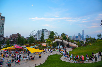 Group of people in park against buildings in city