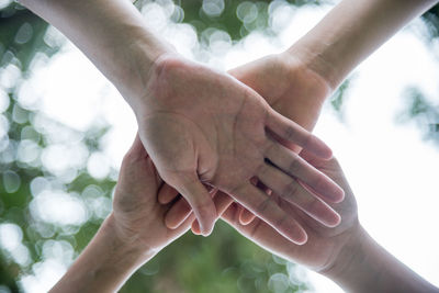 Cropped image of friends stacking hands