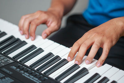 Man playing electronic piano keyboard. closeup of black and white piano keys.