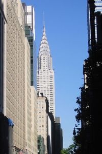 Low angle view of modern buildings against clear blue sky