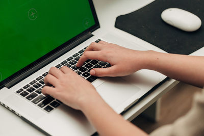Cropped hands using laptop