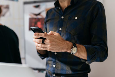 Midsection of man using mobile phone