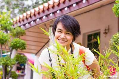 Portrait of smiling woman against plants