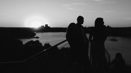 Silhouette of people in water at sunset