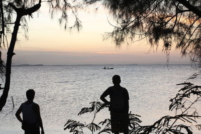 Rear view of men looking at sea against sky