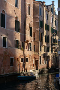 Boats in canal amidst buildings in city