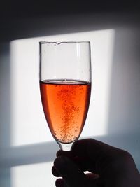 Close-up of hand holding beer in glass