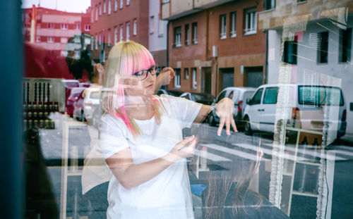 Woman standing by glass window