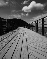 Surface level of boardwalk on footpath against sky