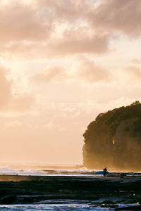 Scenic view of sea against sky with surfer